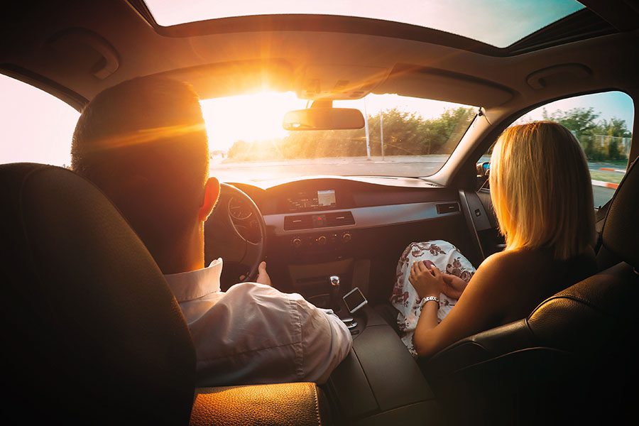 It’s Your Turn to Earn Rewards - Husband and Wife Sitting in the Front Seat of a Car Driving into the Sun